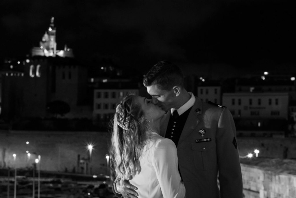 A kiss from the bride and groom under the gaze of the bonne mère of Marseille