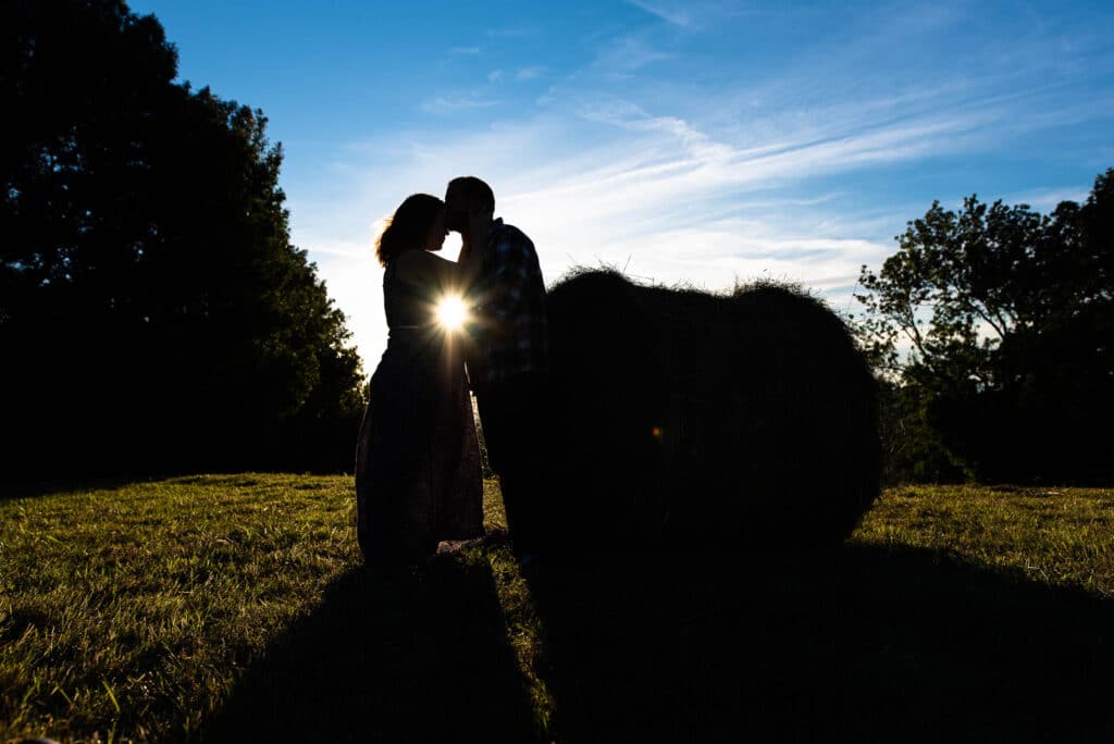 Fin de séance grossesse devant le soleil couchant dans les champs