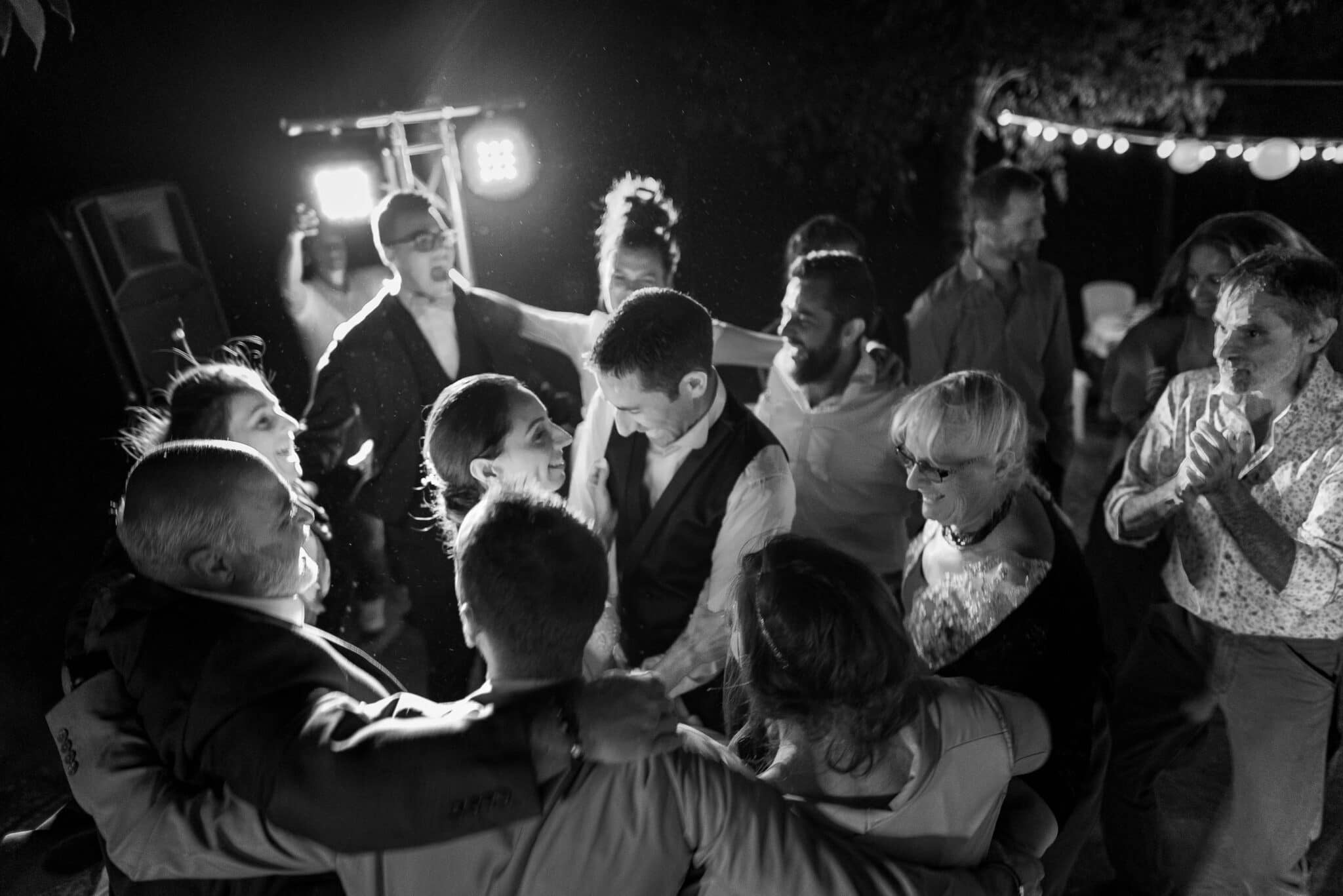 The bride and groom and guests dance